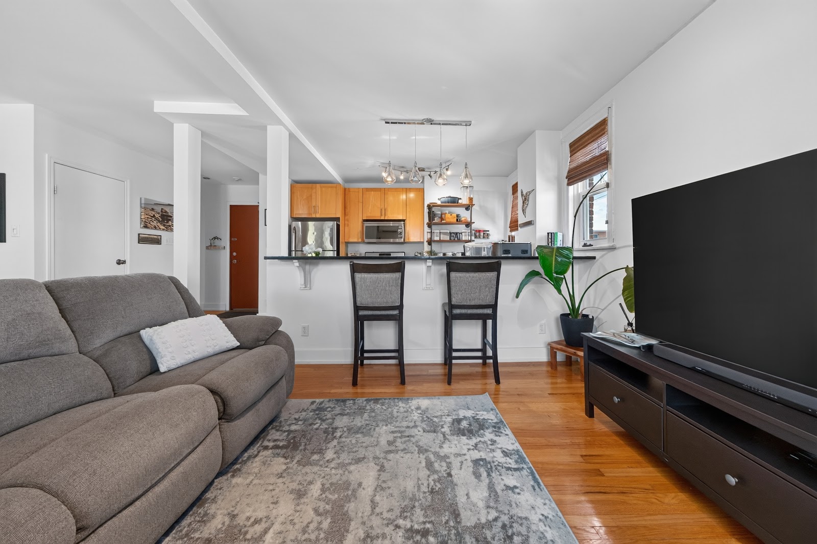 Living room with hardwood floors opening to the kitchen