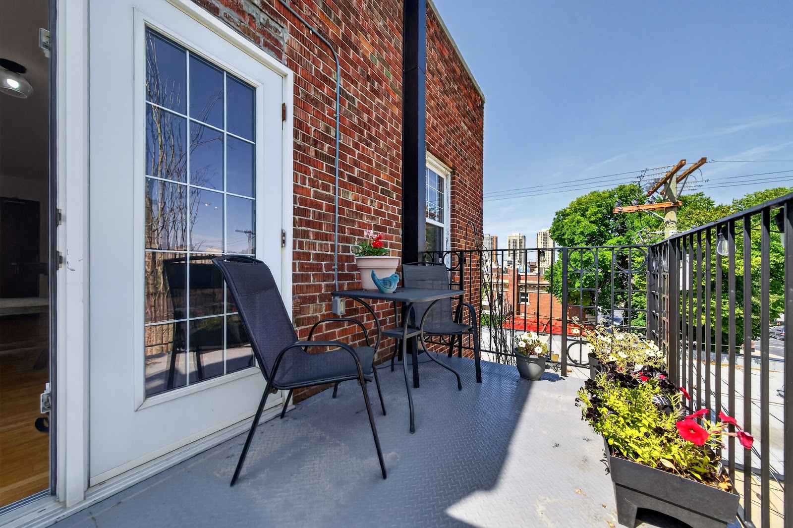 Balcony with seating, brick wall and the Village beyond